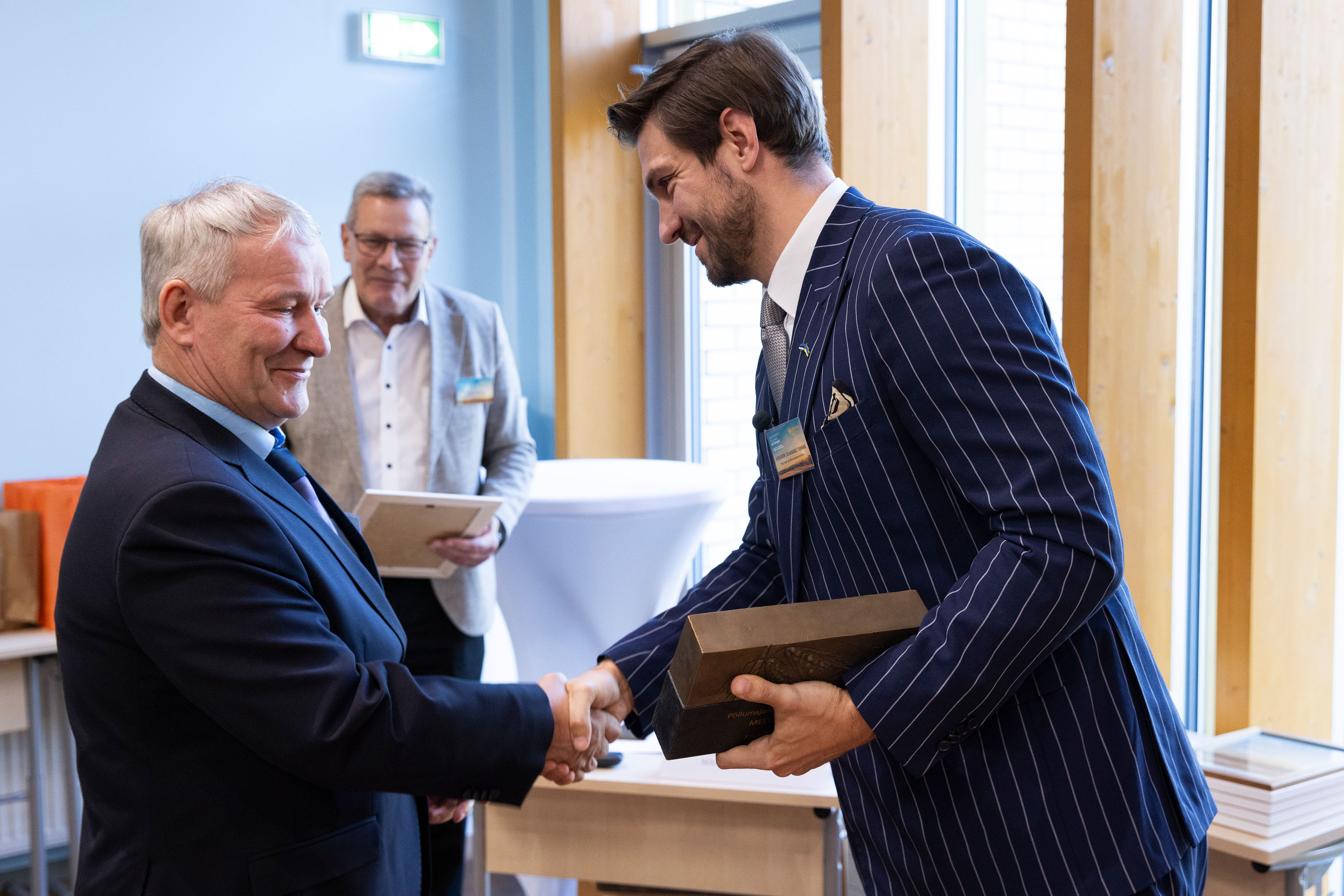 Kaks meest kätlevad. Parempoolne hoiab vasakus käes karpi. 